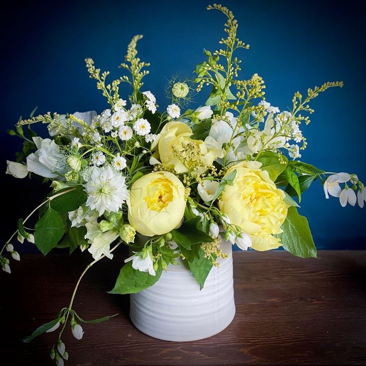 A bright yellow and white bouquet with budding greens