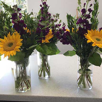 Bright arrangements with sunflowers and purple accents
