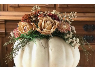 Gorgeous autumn colored florals bursting through the top of a pumpkin base
