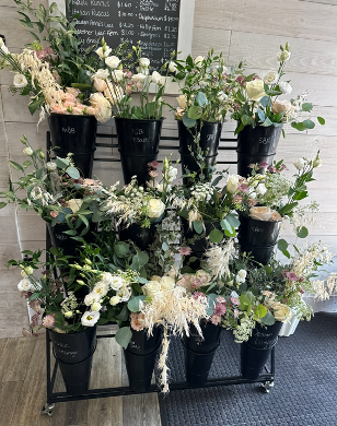 Overflowing shelves of flowers and greenery